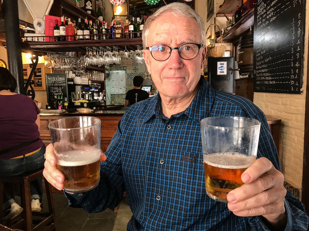 Dive Bar Survival Guide / Rich handing me a beer at a Seville dive bar / Karen McCann / enjoylivingabroad.com